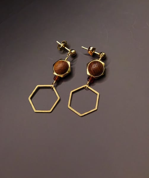Featuring Waxed Wood Beads, Gold Hexagon Charms, Garnet, and Stainless Steel Gold Ear post