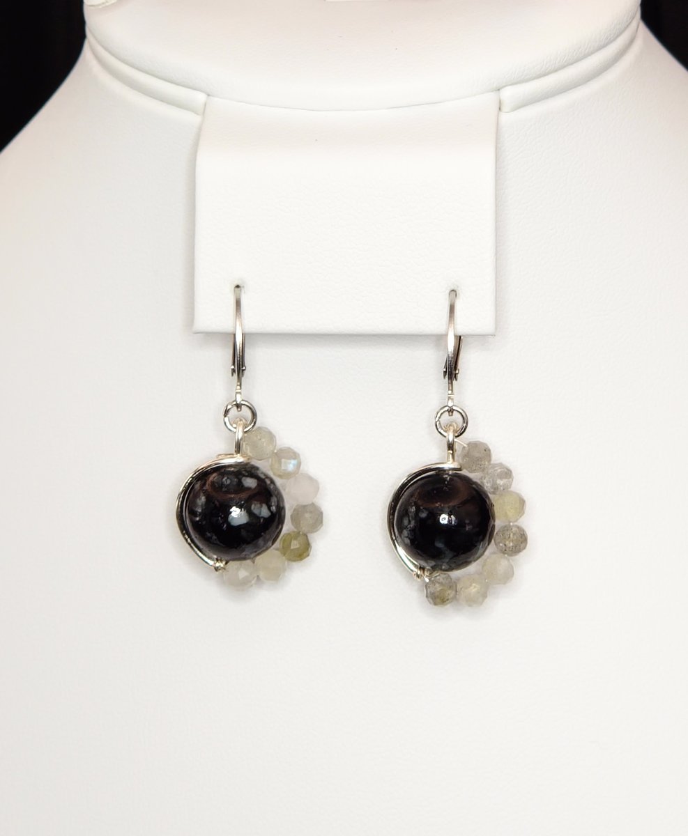 An asymmetrictal design featuring a Snowflake Obsidian center and Labradorite accents
